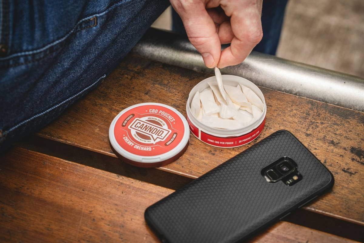 Canndid CBD Pouch tin open being used on bench outside