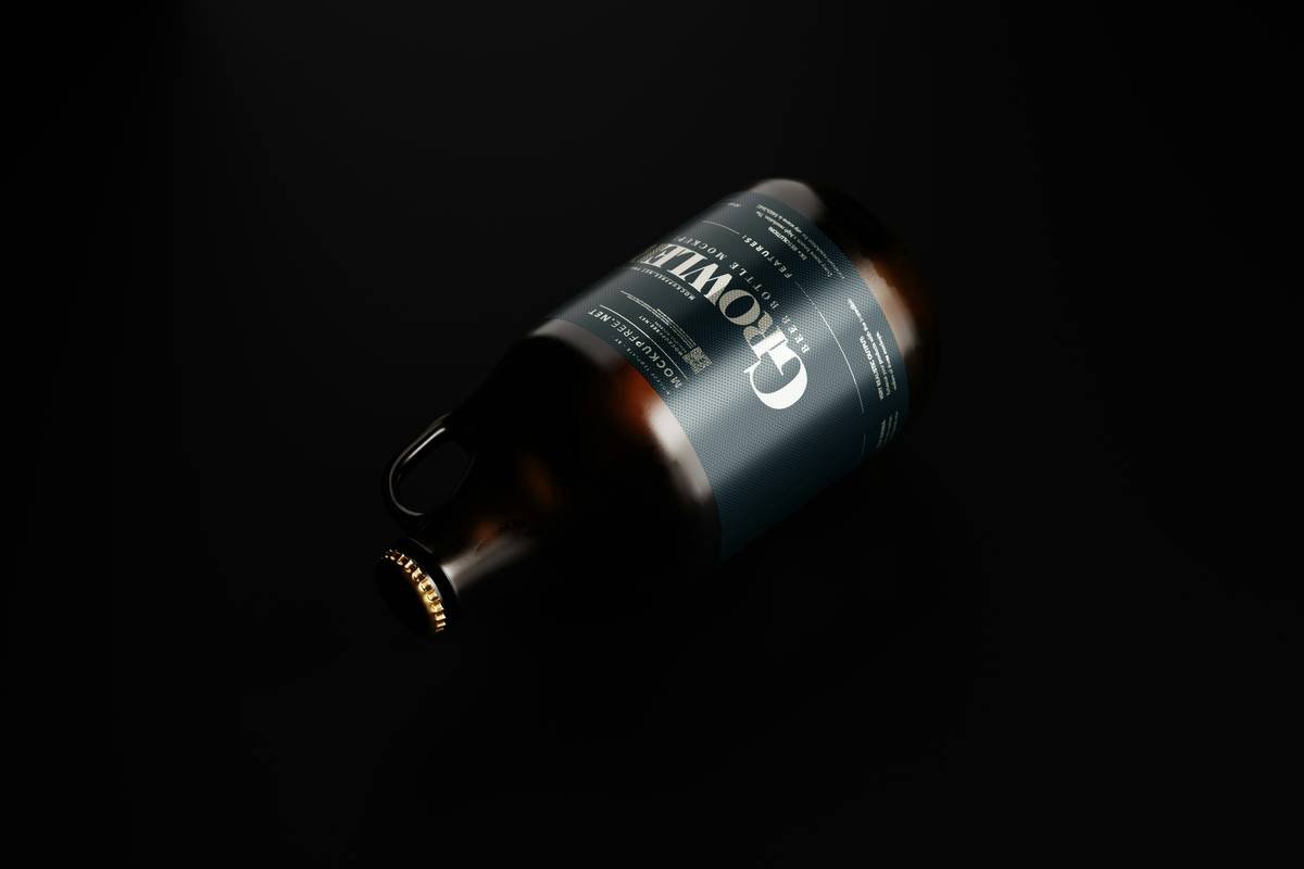 Growler Style Beer Bottle Mockups, growler style large beer bottle mockup set featuring an amber glass beer bottle with a handle. Download this mockup set for free from Mockup Free - https://mockupfree.net