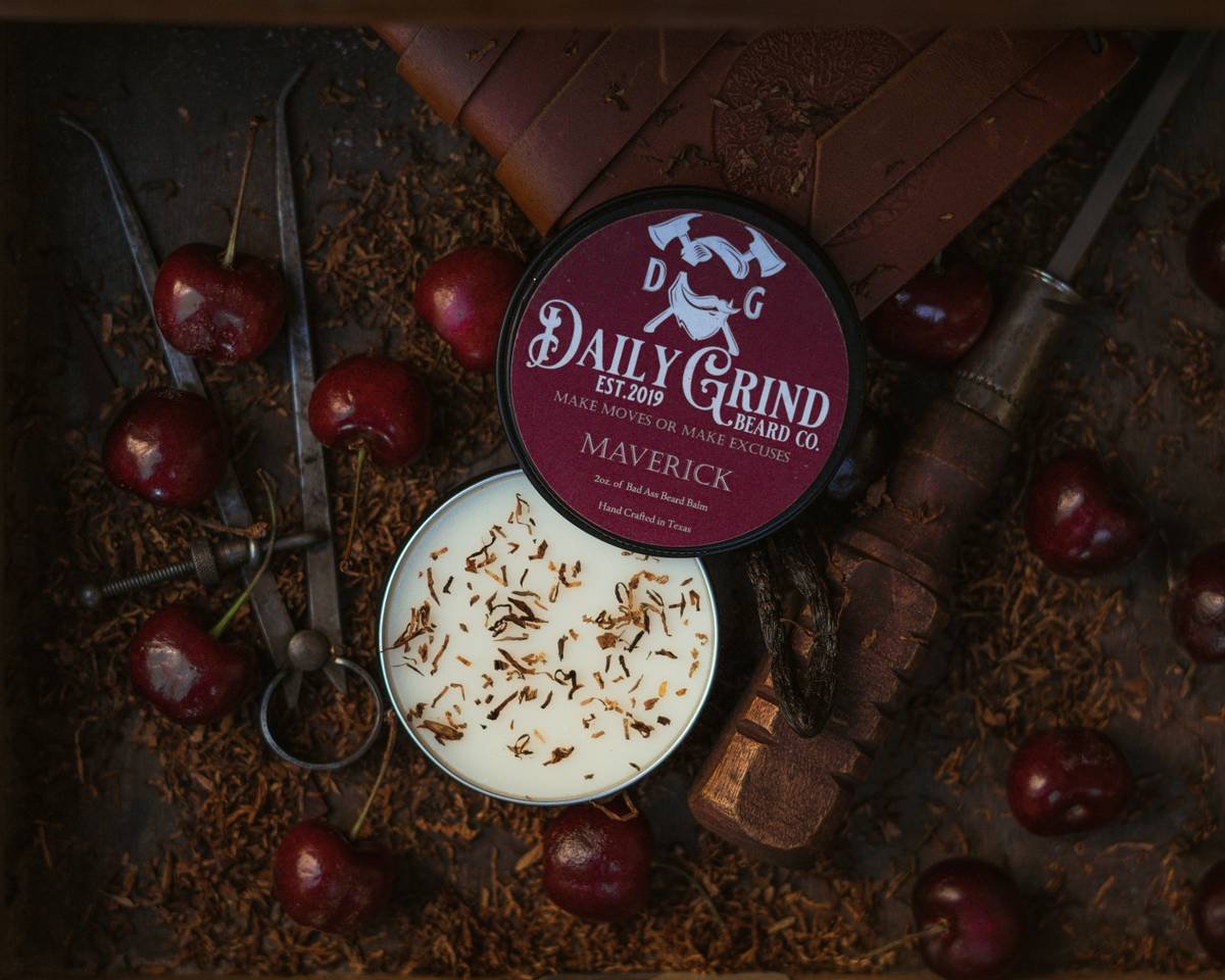 Product photo of Maverick Beard Balm by Daily Grind Beard Co. Product Photography by branding photographer Lance Reis in Portland Oregon. Elements of Tobacco, Wood, Cherry, and Vanilla were added to visually showcase the scents you can expect with Maverick. Did you discover us here? Say hi on insta: Kickassdesigns & daily_grind_beard_co