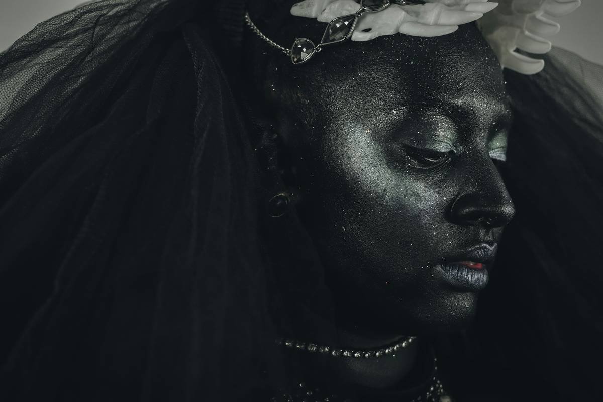 Woman with dark body paint and glitter