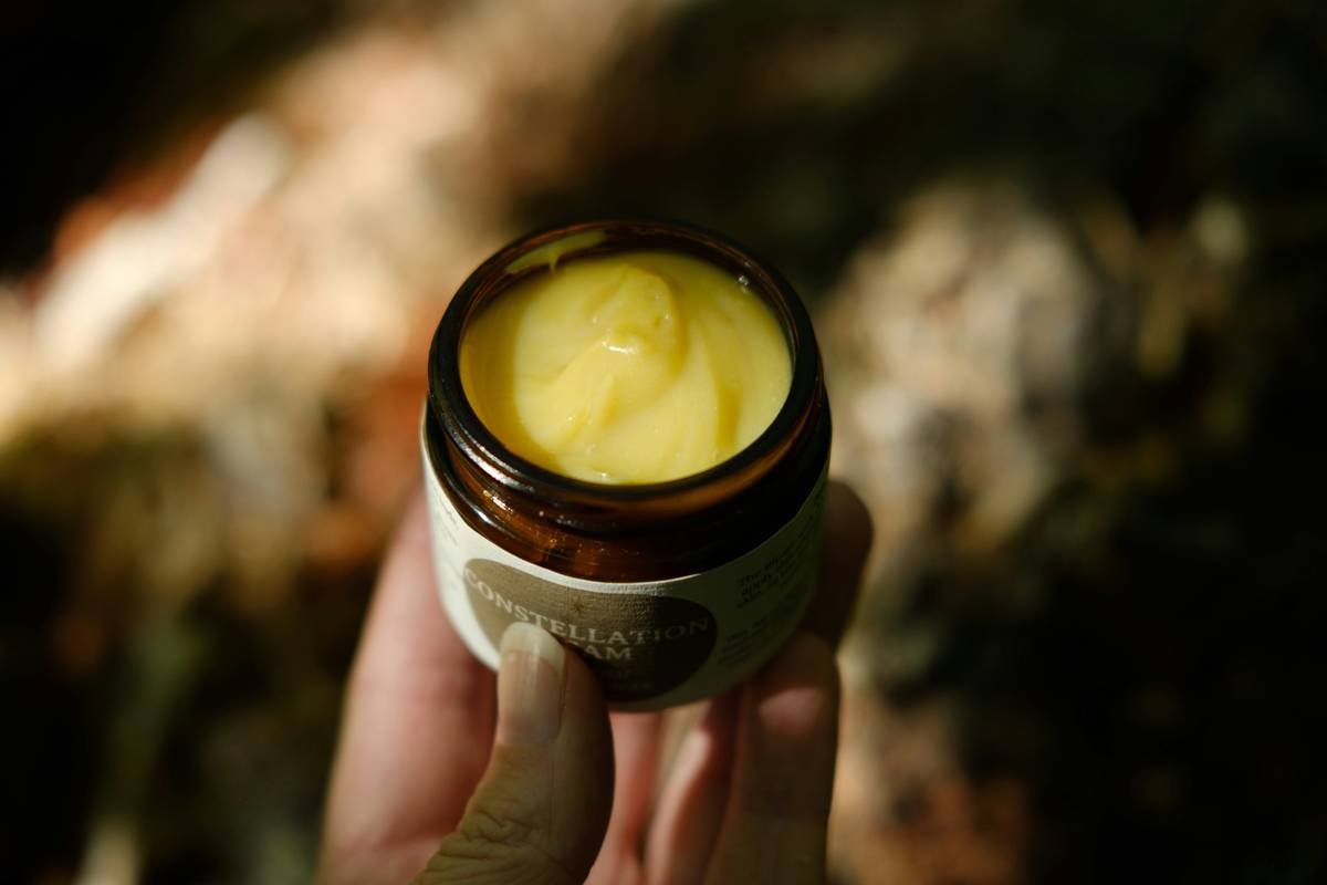 Man applying beard grooming essentials balm to his beard with fingertips